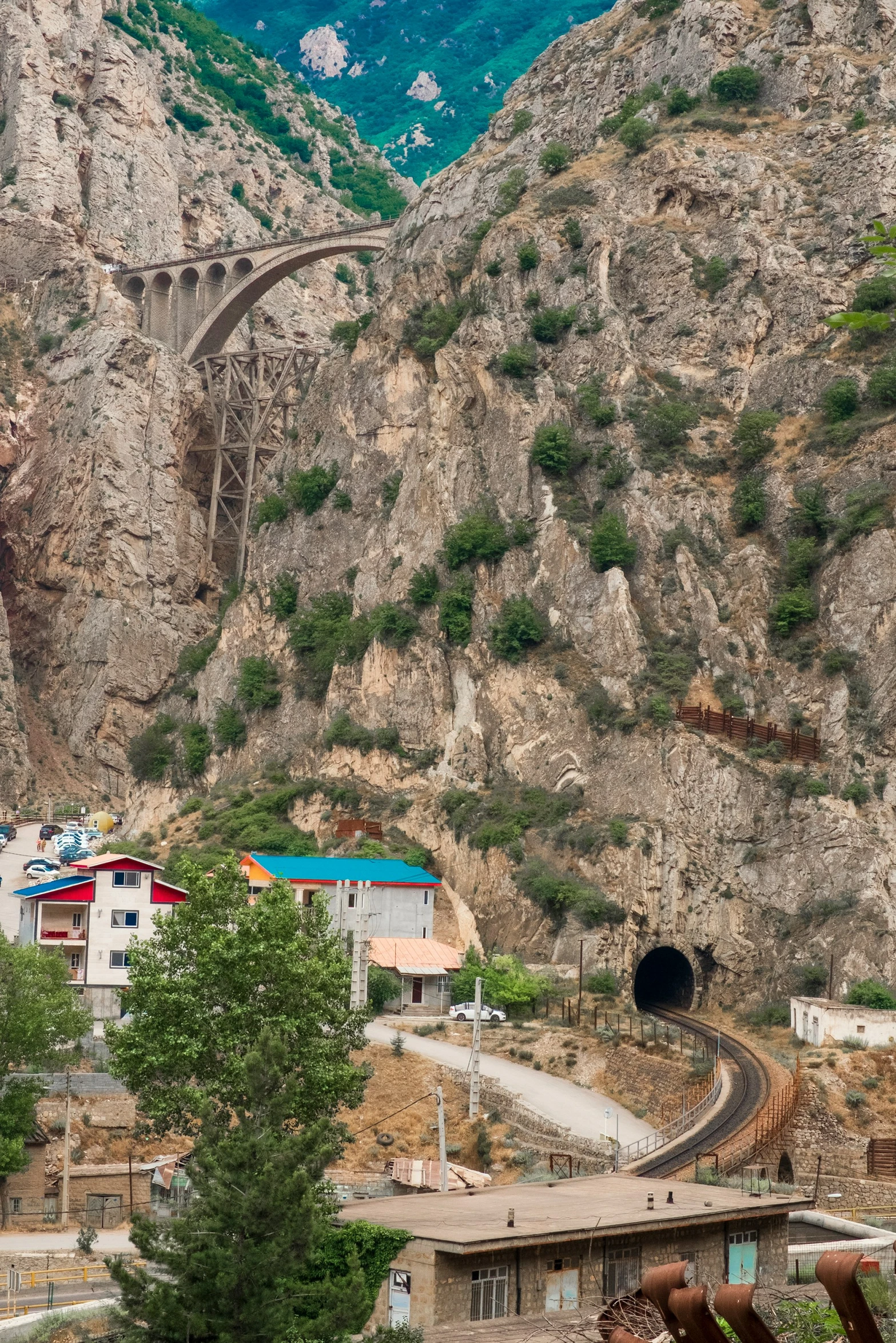 a train traveling through the mountains towards the station