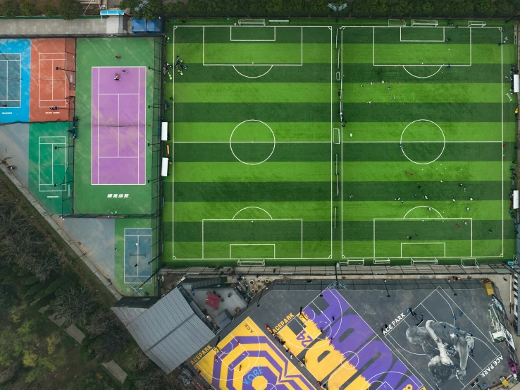 an aerial po of a tennis court and field