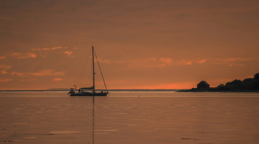 a sailboat sails at sunset on the ocean