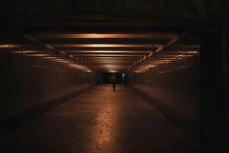 a long tunnel with two people walking through it