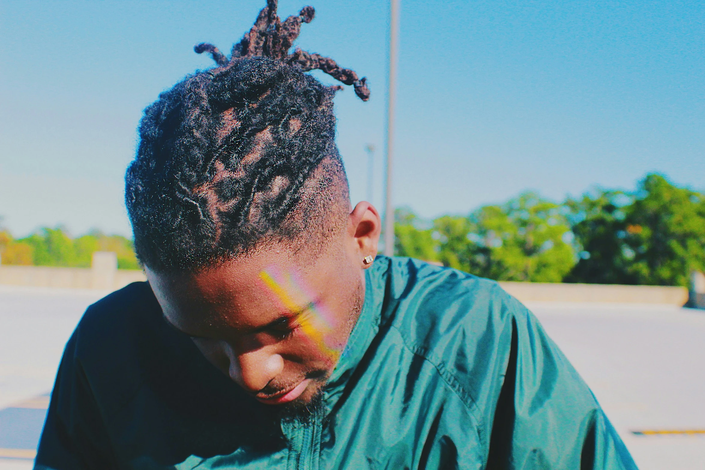 a woman wearing a jacket and long dreadlocks on her face