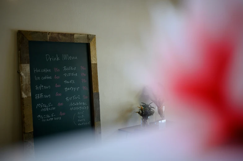 a blackboard sits near a window and vases