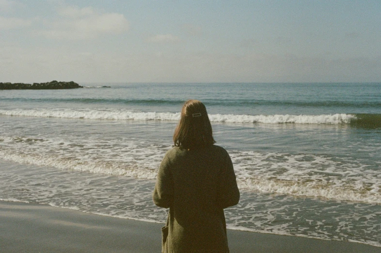 a woman is looking at the ocean from her own side