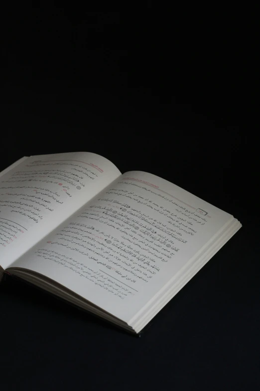 an open book laying on top of a black table