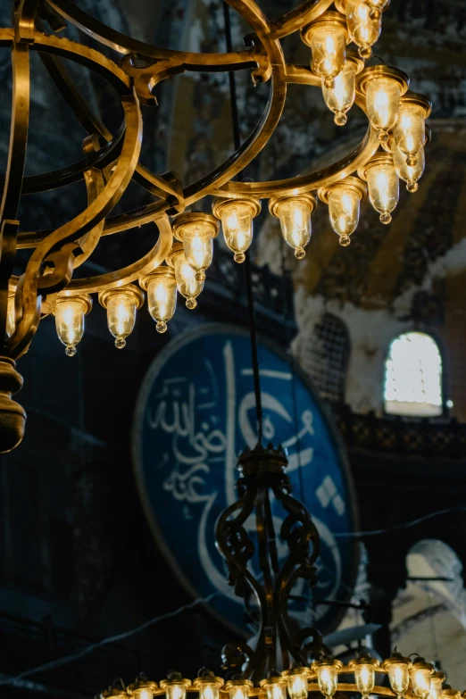 a chandelier in front of the clock tower and the name of the city