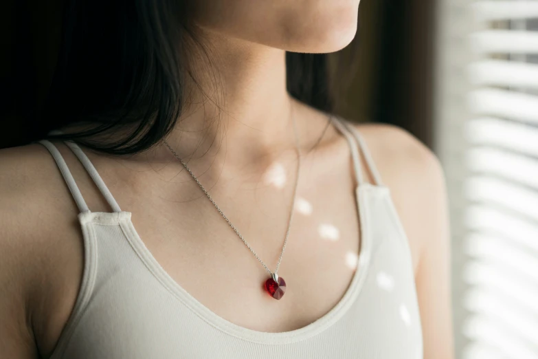 a women wearing a red heart shaped pendant necklace