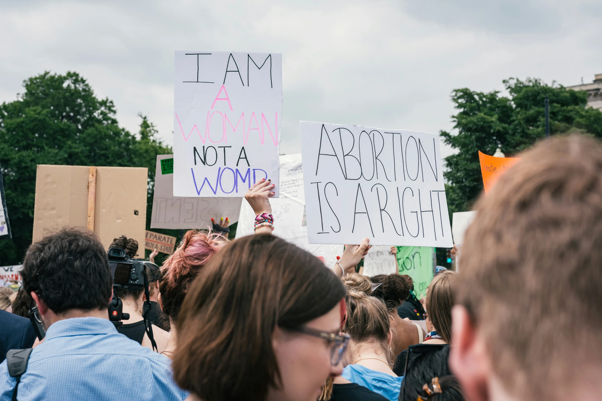 people holding signs, protesting against war and hate