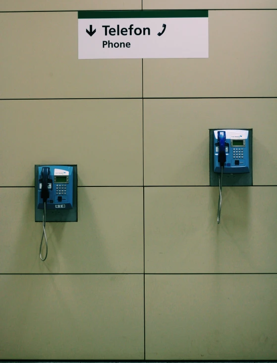 two cell phones are next to the wall sign