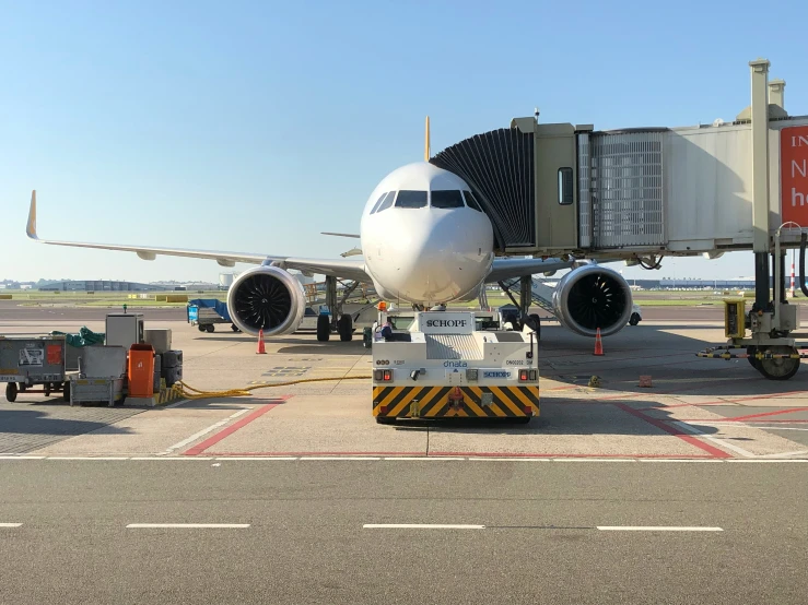 airplane being loaded with cargo and onlookers by man in orange vest