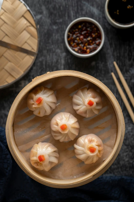 a bowl filled with little asian dumplings on top of a table