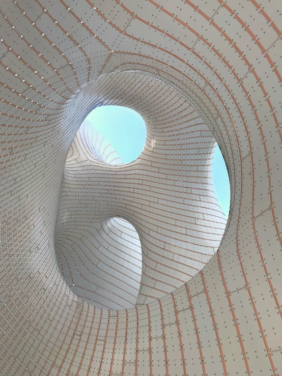 a modern art structure that is surrounded by brick