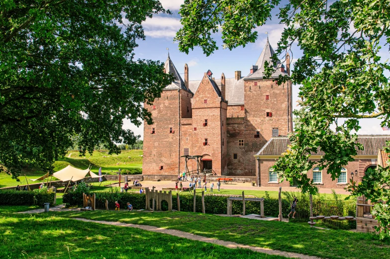 a brick castle with tall towers under a leafy tree