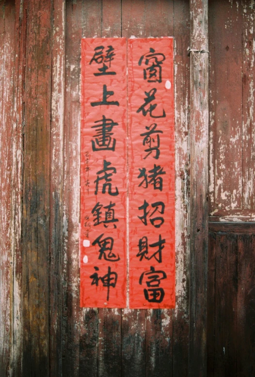 a wooden wall with a red painted sign