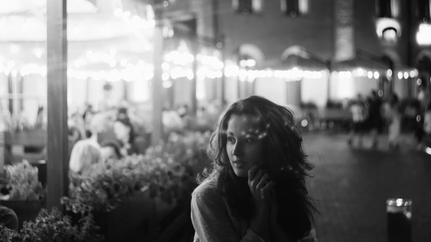 a woman stands in a city at night