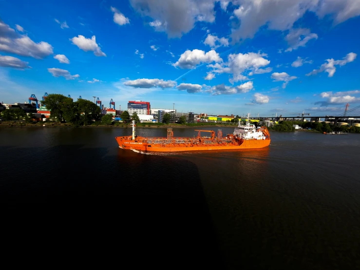 a orange boat floating on top of a lake