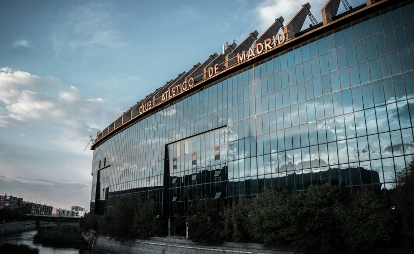 the sky is blue and cloudy behind a large building with its reflection