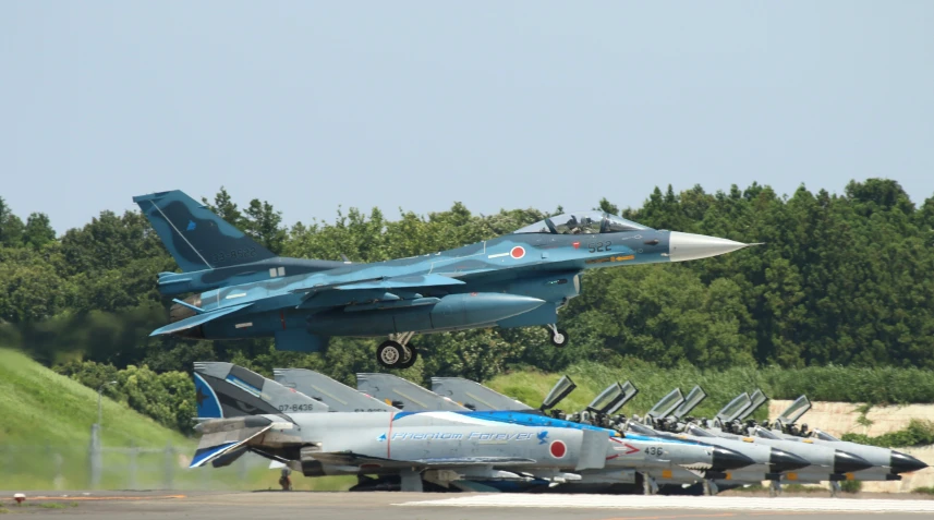 several different colored jets sit on display at an air force museum