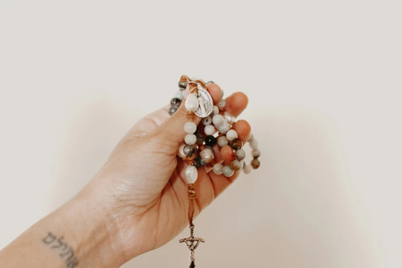 a person holding a rosary in their hand