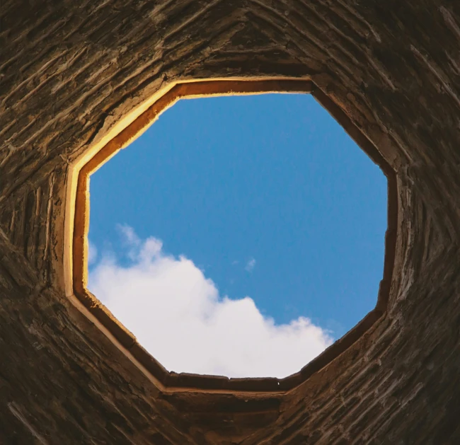 a round window with a sky in the background