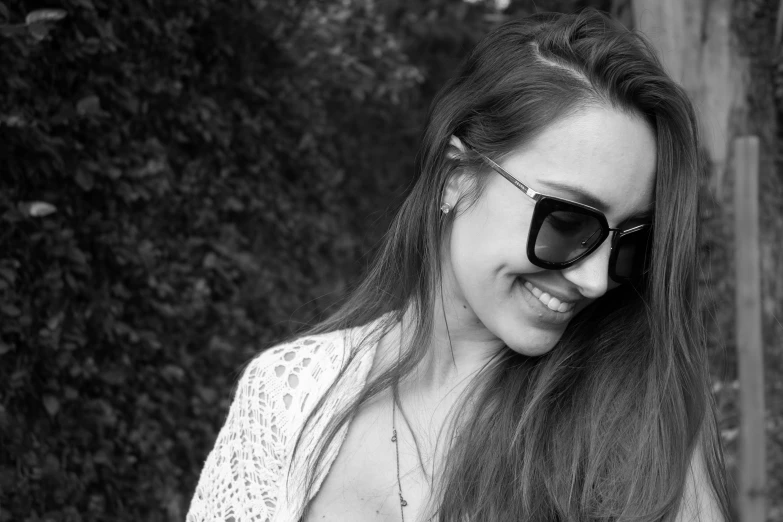 a beautiful young woman in sunglasses talking on a cell phone