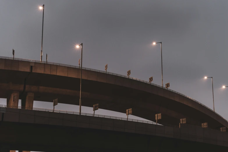 several traffic lights and street lamps above a bridge