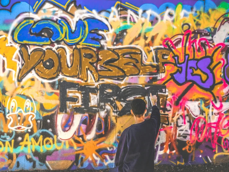 a person writing on graffiti written on a wall