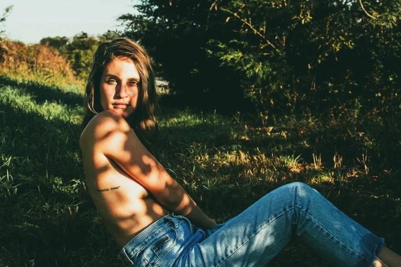 a man with long hair sitting on the ground