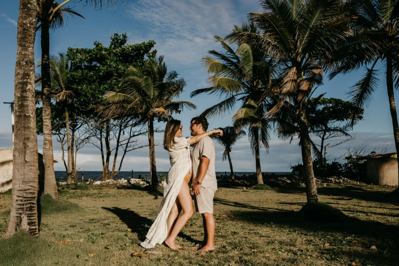 two women standing together by the palm trees