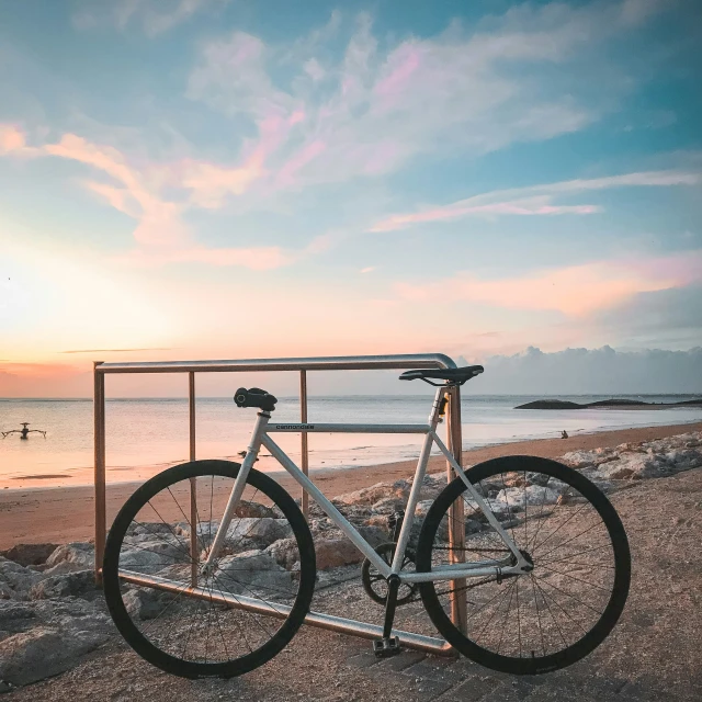 a bike leaned up against a railing at the beach