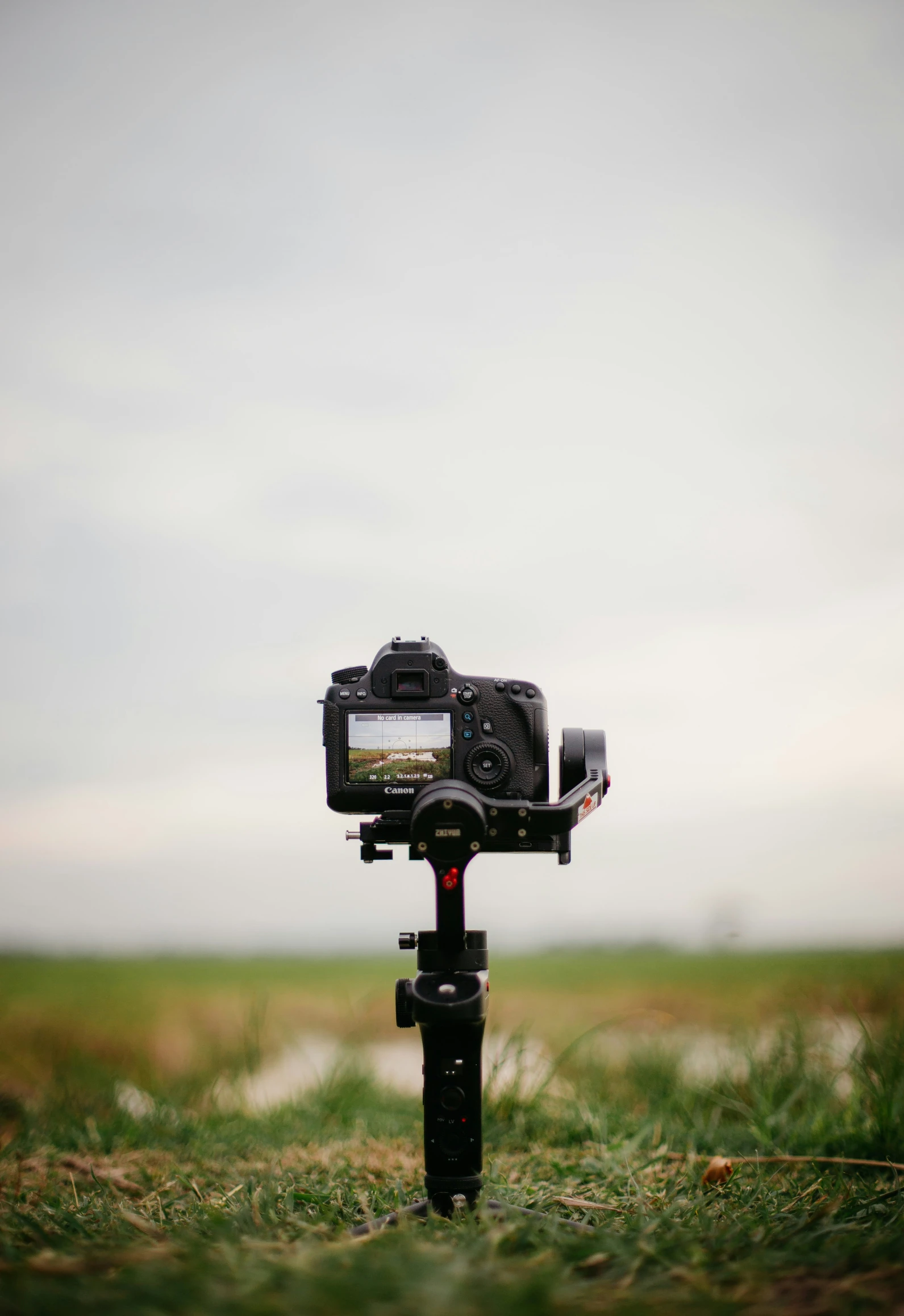 a black camera on top of a tripod on a field