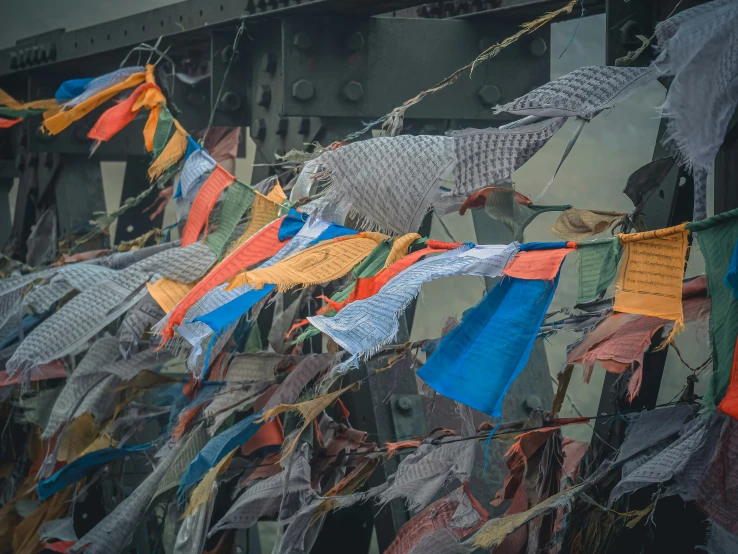 many colorful flags and prayer ropes hanging from a ceiling