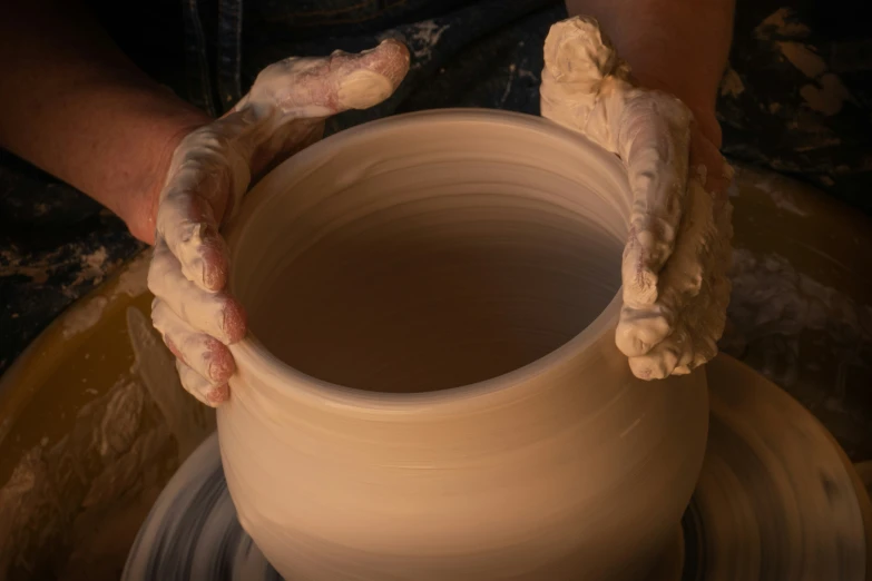 hands and the pot are being held by someone