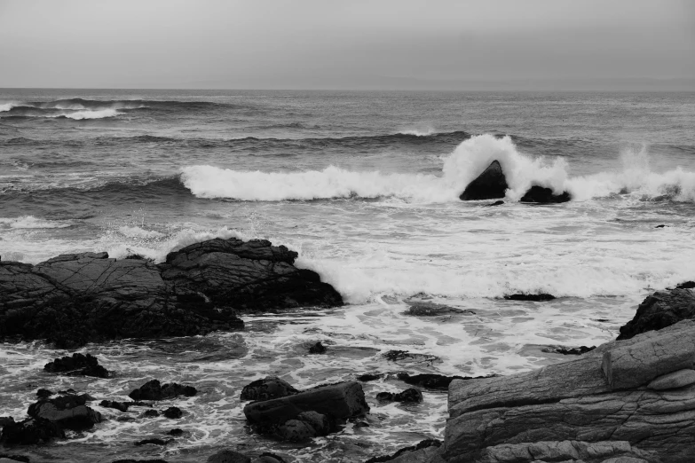 an ocean view with waves crashing on rocks