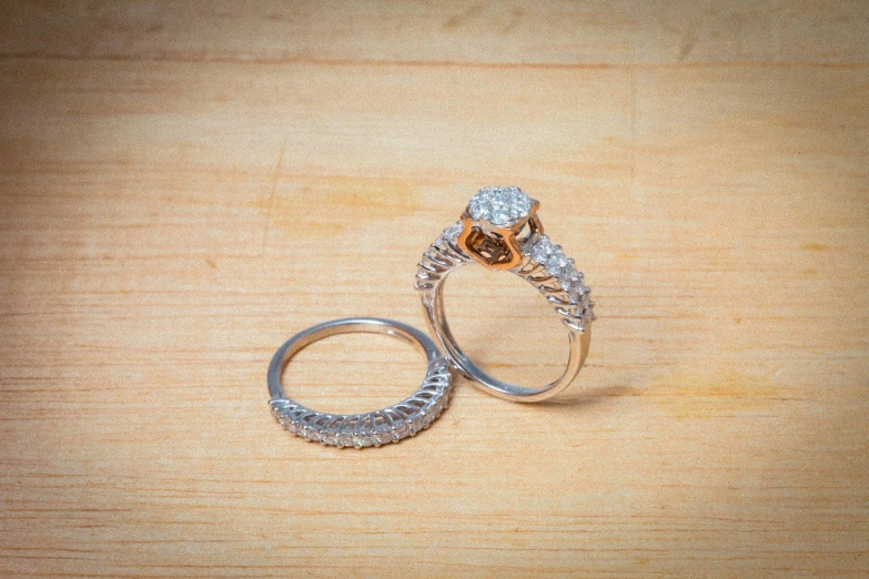 two wedding bands are shown on top of a table