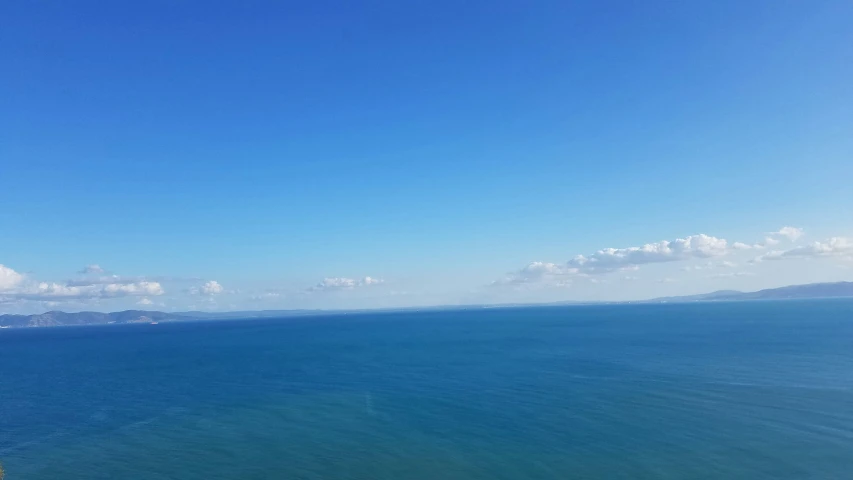 a person standing on a cliff in the middle of the ocean