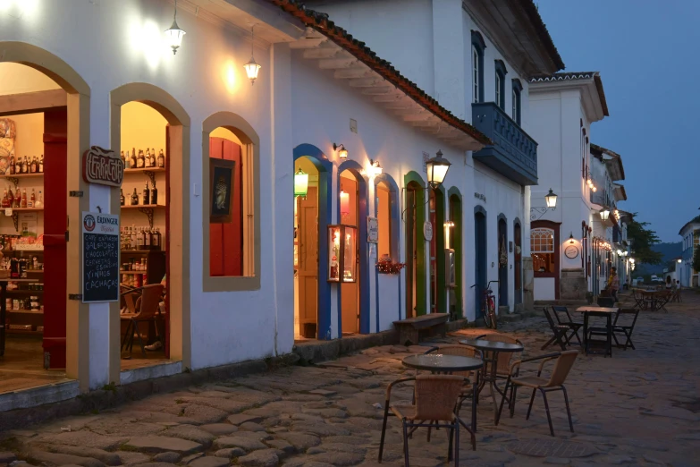 some white houses a sidewalk lights and tables