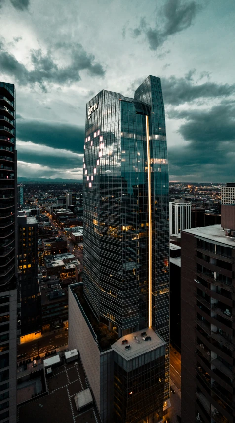 a very tall glass building near many buildings