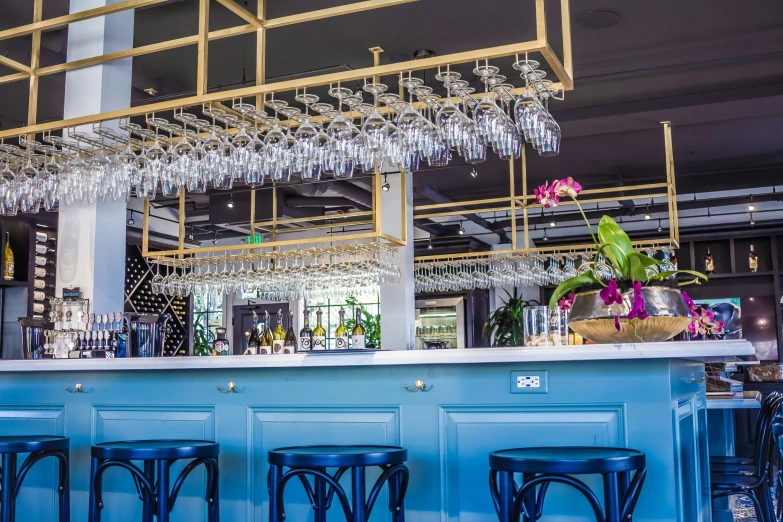 a bar with stools next to it and many chandeliers on the top