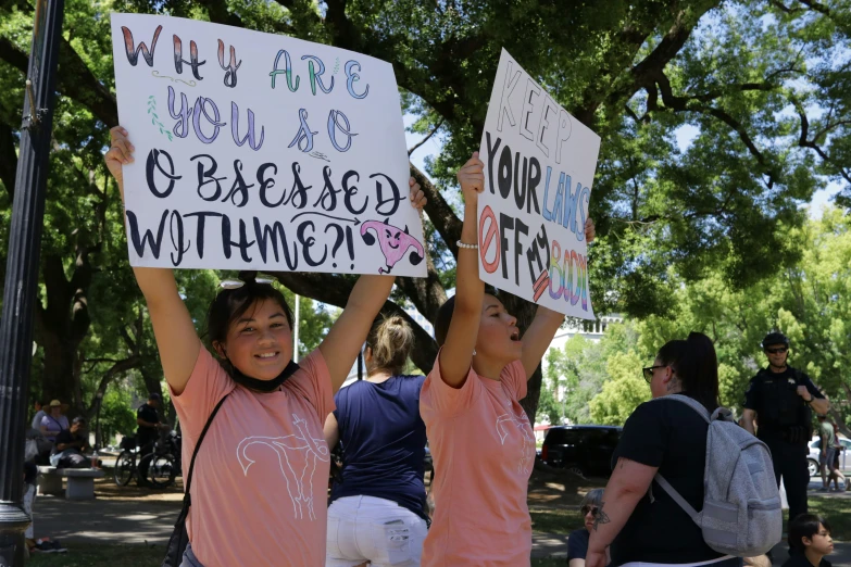 two children hold signs as people look on
