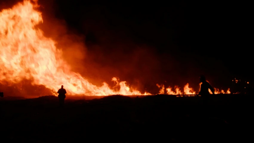 a large fire is burning in a field