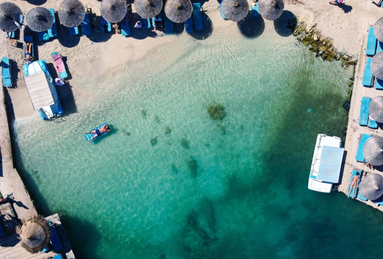 a sandy beach with blue beach chairs and blue ocean water