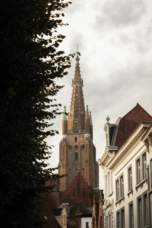 a church tower towering over the middle of a street