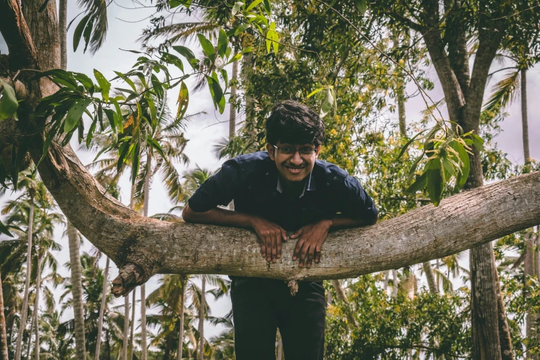 a man leaning on a tree nch with a smile on his face