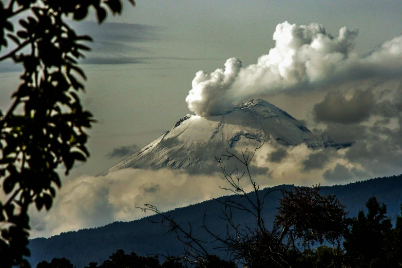 a white mountain covered in a cloud of smoke