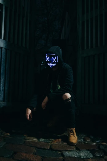 a man with a glowing mask on sits down