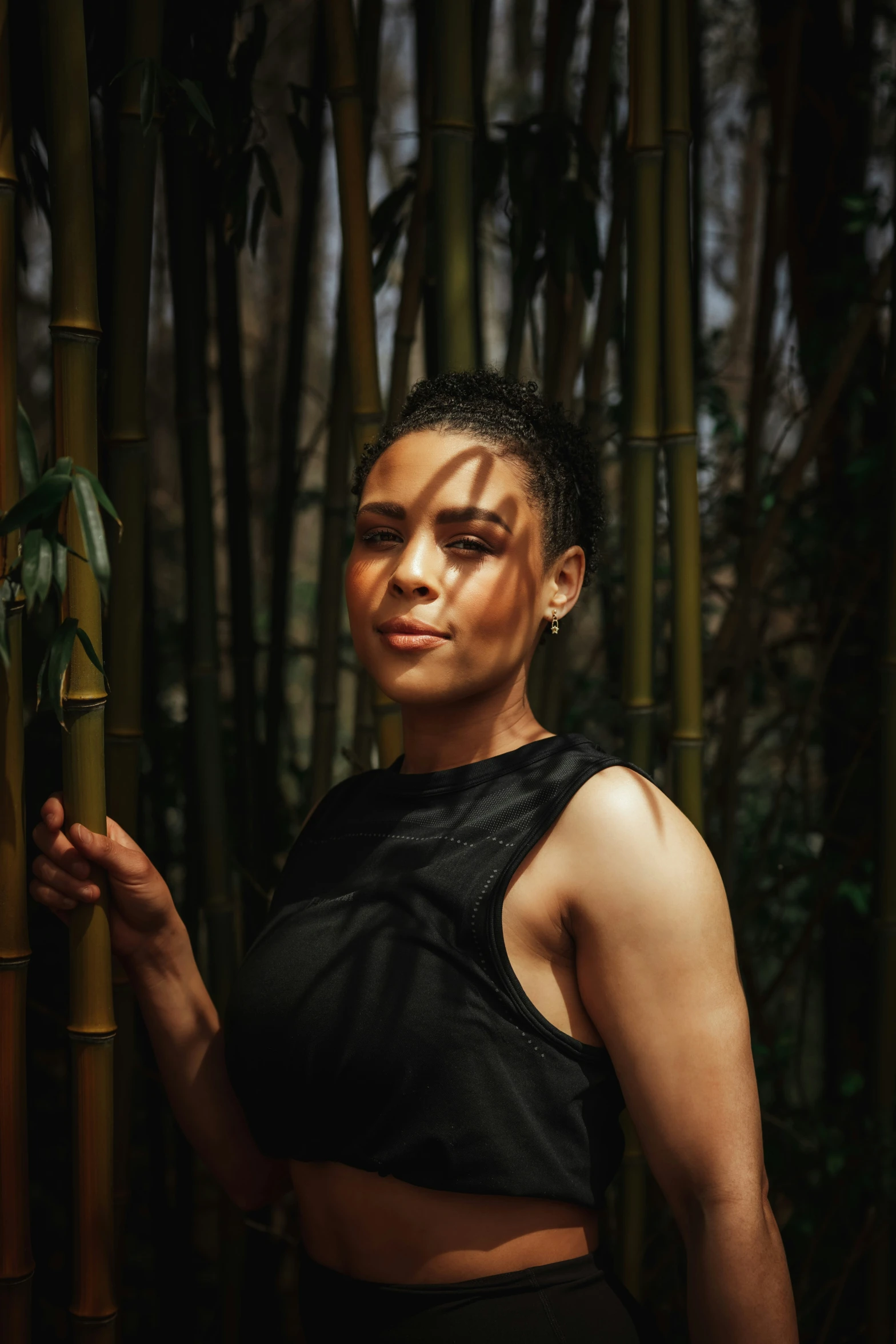 a woman in a black top holding bamboo stems