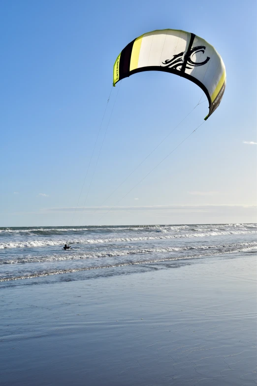 a person holding onto a kite while standing in the water