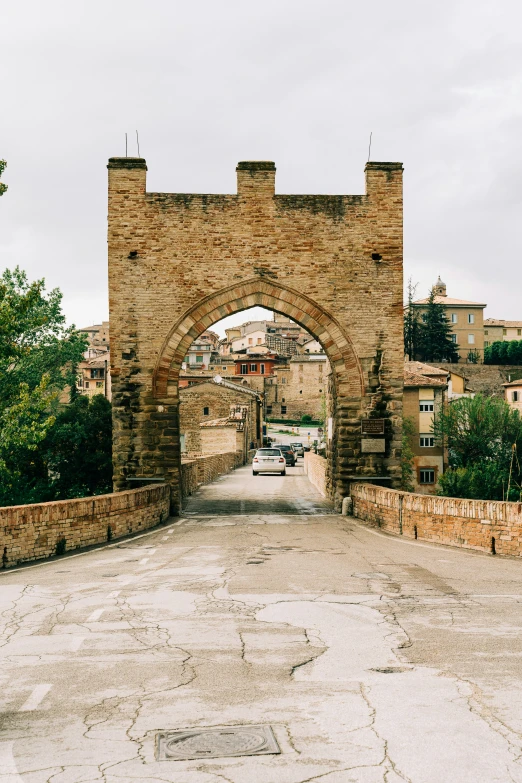 a stone gate on the side of a road