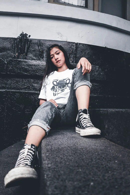 young lady sitting on steps looking down at camera