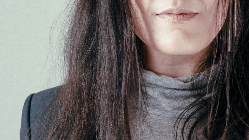 a woman with bangs and long hair, looks directly into the camera